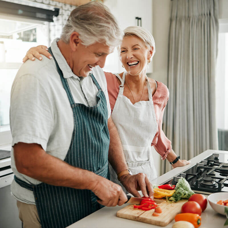 senior couple cooking healthy dinner with vegetables