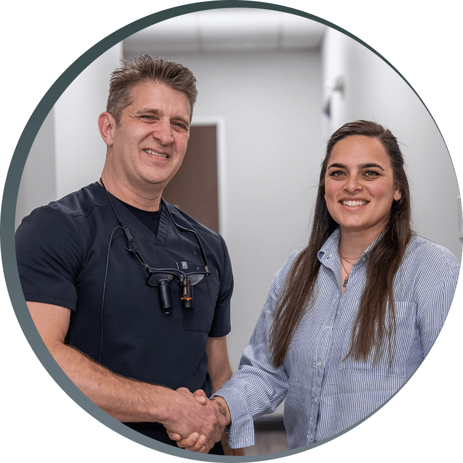 Dr. Justin Tooke smiling and shaking hands with a patient